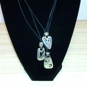 Brighton on three pendants on black cord and another pendant near back closure